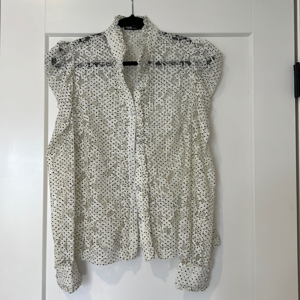 White lace top with black dots and diamond looking buttons